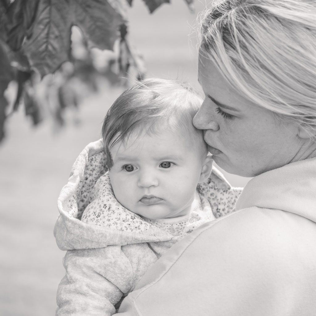 image of a mum holding a baby in the park